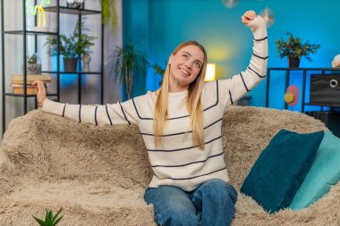 Stresli bir iş gününden sonra dinlenen beyaz kadın kanepede uzanmış gülümsüyor. Sessizliğin tadını çıkarıyorum. Rahatlıyorum. Kapalı mekanda rahatlıyorum.