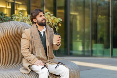 Mutlu Hintli genç adam sabah kahvesinin tadını çıkarıyor sıcak içecek ve dışarıda gülümsüyor. Dinleniyorum, ara veriyorum. Şehir merkezindeki şehir merkezinde oturan İspanyol adam kahve içiyor. Kasaba yaşam tarzları