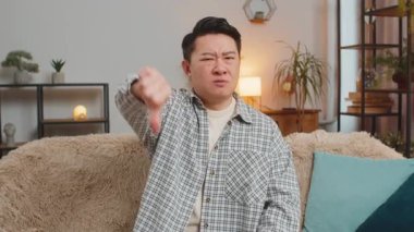 Hoşlanmamak. Sinirli bir Çinli 'nin portresi işaret dilini gösteriyor. Memnuniyetsizliğini dile getiriyor. Ev içindeki kötü işleri tasvip etmiyor. Oturma odasındaki kanepedeki hoşnutsuz genç adam.