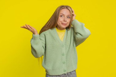 Ne diyecegimi bilmiyorum. Kafası karışmış Kafkasyalı genç bir kadın belirsiz bir sorudan utanıyor, kuşkuları yok, cevapsız bir fikir, bilgisiz bir belirsizlik. Sarı arka planda izole edilmiş sarışın kız.