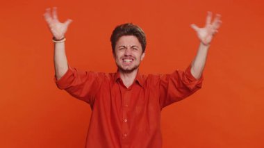 Gerginlikten çığlık atan sinirli, beyaz bir adam... korku, umutsuzluk... şaşkınlık, şaşkınlık... sinirsel kavgayı ifade eder. Yakışıklı genç adam turuncu stüdyo geçmişinde izole edilmiş.