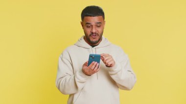 Mutlu Hintli genç adam akıllı telefon daktilo kullanıyor ve bağırıyor 