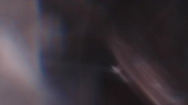 Çok renkli ışık siyah arkaplanda 4K görüntü sızdırıyor. Stüdyoda gaz sızıntısı var. Doğal aydınlatma ışınları bokeh etkisi. Çekimlerinizi birleştirmek, videoyu biçimlendirmek, geçişlerinizi
