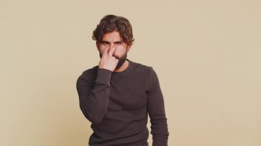 Gözüm üzerinde. Kendine güveni tam genç Hintli adam, kameraya ve gözlerine bakıyor, jest yapışını, birini gözetlediğini görüyorum. Yakışıklı, sakallı Hintli adam bej renkli stüdyo arka planında tek başına..