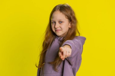 Hey sen! Mutlu genç kız çocuk heyecanla gülümsüyor ve kamerayı ileri doğru doğrultuyor, şanslı oyun kazananını seçiyor, müthiş bir terfi olduğunu gösteriyor. Sarı arka planda izole edilmiş genç çocuklar