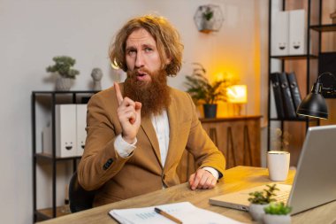 Laptop üzerinde çalışan sakallı Kafkasyalı işadamı el sıkışıyor ve 