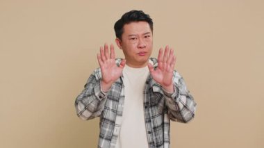 Hey sen, dikkatli ol. Orta yaşlı sert bir Asyalı adam uyarısı, uyarıda bulunan, hayır diyen, dikkatli ol, azarlayan ve tehlikeden kaçınmak için tavsiye veren, onaylanmayan eller. Bej duvardaki Çinli adam.