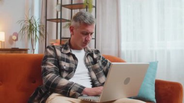 Kafkasyalı, gri saçlı, dizüstü bilgisayarda çalışan, düşünceli, çözümlü bir cevap üzerinde kafa yoran, soru soran, mesajlar gönderen, sınıftan online alışveriş yapan biri.