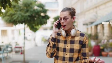 Kafkasyalı turist arkadaşlarıyla uzaktan iletişim kuruyor, telefonla konuşuyor şehir caddesinde beklenmedik iyi haber dedikoduları yapıyor. Şehir yaşam tarzları açık havada.