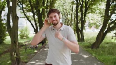 Sporcu spor koşucusu maraton koşusu yapıyor, kulaklıkla müzik dinliyor. Sabah parkta kardiyo çalışması var. Sağlıklı yaşam tarzını seven mutlu genç bir adam. Aktif sporcu koşucu.