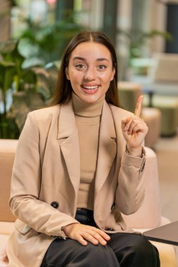 Evreka. Düşünceli, zeki, ilham verici, beyaz bir kadın parmağını kaldırarak yaratıcı bir plan yaptı. Otel lobisindeki ilham verici soruyla heyecanlandı. Kız koridorda oturuyor.