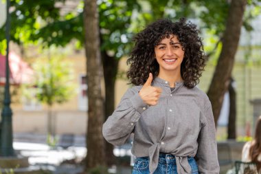 Gibi. Mutlu Kafkasyalı genç kadın olumlu bir cevap vererek olumlu yanıt veriyor. Reklam önerileri, iyi bir geri bildirim, açık havada başarı zaferini kutluyor. Şehir sokağındaki adam.