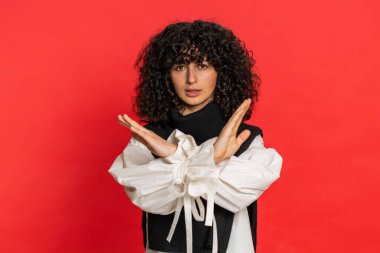 Dur, yeter. Kafkasyalı bir kadın, el ele tutuşmak yok diyor. Bitiş çizgisinde el ele tutuşmak yasak erişim, iletişimin kopması, vücut dili tehlikesi uyarısı. Kırmızı arka planda genç bir kız