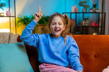 Evreka. Düşünceli, zeki, ilham verici çocuk parmağını kaldırır yaratıcı bir plan yapar. İyi bir fikir motivasyonuyla heyecanlanır, evde sorular sorulur. Çocuk kanepede oturuyor.