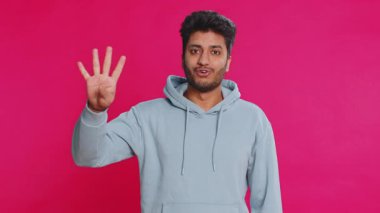 Doğum günü kutlamasına geri sayım zafer kazandı. Hintli adam beşten bire sırayla sayıyor. İçerideki pembe arka planda izole edilmiş Arap genç adam. Mutlu yıllar Mutlu Noeller