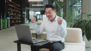 Dizüstü bilgisayarda çalışan Çinli genç işadamı ani bir zaferle, piyango galibiyeti hedefiyle, iyi bir kariyer haberiyle şok oldu. Modern ofis lobisinde oturan heyecanlı, serbest çalışan, yumruklarını sıkan adam..