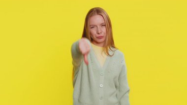 Hoşlanmamak. Mutsuz, Kafkasyalı kadın işaret dilini gösteriyor hoşnutsuzluğunu dile getiriyor, olumsuz tepkiler veriyor. Sarı arka planda oldukça çekici bir kız.