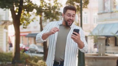 Kafkasyalı mutsuz genç adam cep telefonu kullanıyor. Kötü bağlantı kaybediyor. Servet kaybı yok. Şehir caddesinde duran erkek gezgin..