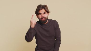 Tartışma. Kızgınlık ve hoşnutsuzlukla el kol hareketi yapan genç Lübnanlı adam başarısızlıktan dolayı azarlıyor, bunun neden olduğunu soruyor. Latin erkek, bej renkli stüdyo arka planında izole edilmiş..