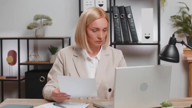 Finansal grafik belgeleriyle çalışan Kafkasyalı serbest muhasebeci, çizelgeler için vergileri hesaplıyor ve ofis masasında raporlar hazırlıyor. Dizüstü bilgisayarda çalışan iş kadını, gider bütçesi planlama.