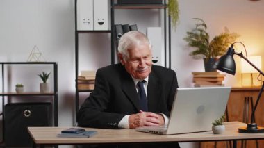 Üst düzey işadamı, ofis masasında dizüstü bilgisayarla çalışıyor. Çalışanlarla internet üzerinden iletişim videosu görüşmesi yapıyor, patron. Büyükbaba Yöneticisi serbest çalışan adam web kamerasına bakan destek servisleri.