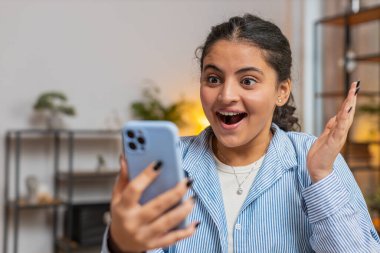 Aman Tanrım. Vay canına. Heyecanlı, mutlu, neşeli, beyaz bir kadın akıllı telefon kullanıyor. Daktilo kullanıyor. Harika haberler, zaferi kutluyor. Ofis masasında cep telefonu olan bir kız. Yaşam biçimi.