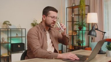 Kafkasyalı genç işadamı ofis masasında oturmuş soğuk su içiyor diş ağrısının ağız dokunuşu, diş hastalığının acı ifadesi, diş eti hastalığı, diş hastalığı kavramları..