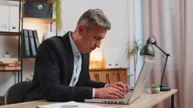 Sıkıcı takım elbiseli uykulu iş adamı dizüstü bilgisayarla çalışıyor esniyor, el ele yatarak ofis masasında uyuyor. Kafkasyalı, serbest çalışan, yorgun, işkolik bir adam. İstihdam, meslek, işsiz