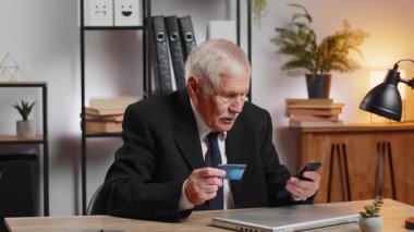 Kafkasyalı kızgın, yaşlı işadamı akıllı telefon engelli kredi kartıyla online alışveriş yapmaya çalışıyor. Kızgın büyükbaba satın alma, banka reddetme sorun ödeme başarısız denge.