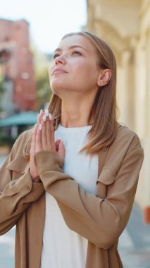 Sakin ol, sakin ol. Genç kız meditasyon yapıyor, elleri sımsıkı kapalı derin nefes alıyor, dua eden gözler kapalı, konsantre düşünceler, dışarıda huzurlu bir zihin. Şehir caddesinde mola veren genç bir kadın.