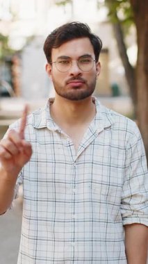 Memnun olmayan Hintli adam nahoş berbat bir fikre tepki veriyor, kötü kaliteden memnun değil, el sallıyor, başını sallıyor hayır, reddet fikri, evlenme teklifini sevme. Genç yetişkin erkek gezgin şehir caddesinde.