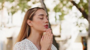 Tanrı 'ya kapalı gözlerle dua eden genç bir kadının portresi dışarıda kutsama, yardım ve af diliyor. Güneşli şehir caddesinde el ele tutuşan güzel kız şans diliyor. Kasaba dini yaşam tarzları.