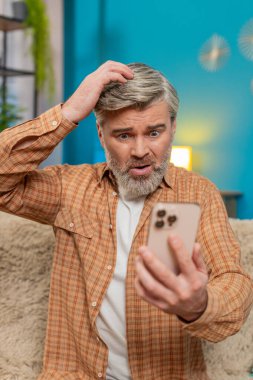 Olgun bir adam evdeki koltukta oturuyor, elinde akıllı telefon tutuyor ve stres belirtileri gösteriyor. Orta yaşlı bir adam kötü haber mesajı alır. Umutsuzluk ve yorgunluk hisseder. Yorgun görünür. Dikey