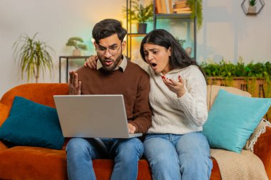 Dizüstü bilgisayar kullanıp evdeki kanepede oturup ağzını kapatan genç çift şok oldu. Hayal kırıklığına uğrayan Hintli aile babası kadın birlikte kötü haber okurken dairede netbook 'ta kaybediyor..