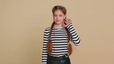 Genç ve mutlu bir kızın portresi. Arkadaşça gülümseyen, mutlu bir yüz ifadesi. Kameraya bakıp dinlenme hayali kuran rahatlama. Bej arka planda izole edilmiş genç çocuklar