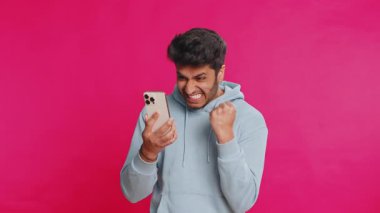 Mutlu Hintli genç adam akıllı telefon daktilo kullanıyor ve bağırıyor 