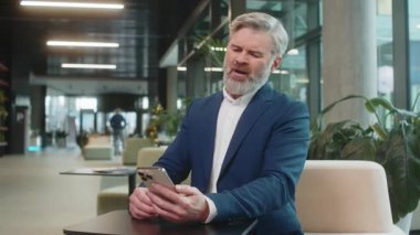 Takım elbiseli bir işadamı akıllı telefon daktilo ile arama yapıyor. Ani piyango sonuçlarını, kötü haberi, servet kaybı ofis lobisini kaybediyor. Koridorda cep telefonu olan üzgün bir girişimci..