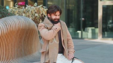 Boğaz ağrısından muzdarip hasta Hintli genç iş adamı elini boynuna koydu. Lübnanlı adam kendini kötü hissediyor. Soğuk algınlığı mevsimi salgını. Soğuk algınlığı salgını.