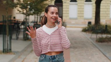 İyi haberler, dedikodular. Akıllı telefondaki hoş sohbetteki mutlu genç bayan dışarıda arkadaşınla sohbet ederken eğleniyor. Şehir caddesinde diş teli takan kız. Kasaba yaşam tarzları
