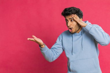 Üzgün genç Hintli adam umutsuzluk yalnızlık, sinir bozukluğu, kaybediyor piyango sonuçları, kötü talih, şanssız haberler karşısında şaşırıyor. Çekici Hindu adam kırmızı arka planda izole edilmiş.