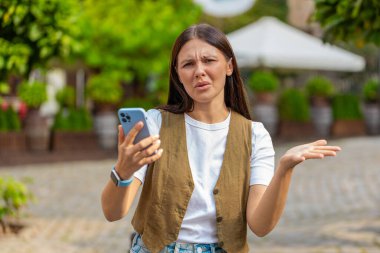 Genç bir kadın akıllı telefon daktilo kullanıyor. Ani piyango sonuçlarını kaybediyor. Kötü haber, servet kaybı, başarısızlık, uygulama hatası. Şehir caddesinde duran bir kız. Kasaba yaşam tarzları.
