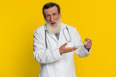 Cep saatini kontrol etmek için kaygılı olan kıdemli doktor kardiyolog işe geç kaldığı için gecikiyor. Eczane yaşlı dedem sarı arka planda yalnız kalmaktan korkuyor.