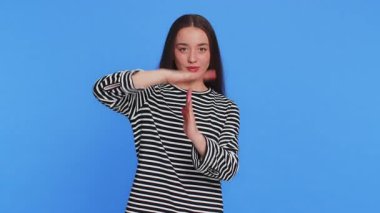 Yorgun ve sinirli genç bir kadın. Mola verme hareketi yapıyor, sınır veya dur işareti yok. Baskı yok. Güzel, esmer, yetişkin bir kız, mavi arka planda izole olmak isteyen çalışmaktan sıkılmış.
