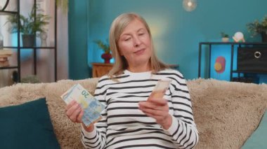 Mutlu Kafkasyalı olgun bir kadın piyango ikramiyesi kazandıktan ya da hediye aldıktan sonra nakit para sayıyor. Büyükannem evde kanepede oturmuş, finansal zafer maaşını kutlarken gülümsüyor.