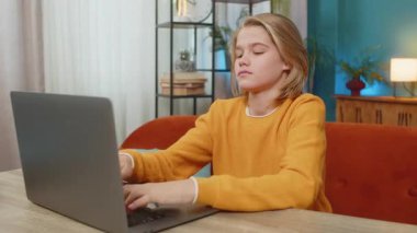 Beyaz çocuk evde bilgisayarında zor bir video oyunu oynarken hayal kırıklığına uğradı. Sinirli bir şekilde klavyeye vuruyor, kaybettiği için üzgün bir şekilde masa masa oturuyor, hayal kırıklığını ifade ediyor.