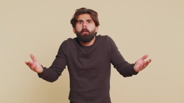 Neden? Samimi, sinirli Lübnanlı bir adam öfkeli bir ifadeyle el kaldırıyor ve sorguluyor, başarısızlığın nedenini sorguluyor. Bej arka planda kafası karışmış Hintli adam.