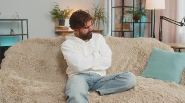 Genç Hintli adam kanepeye uzanmış karın ağrısı ve mide iltihabı şikayeti yaşıyor. Hindu adam ishal, hazımsızlık, peptik ülser pankreatiti geçiriyor..