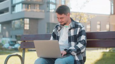 Olgun Kafkas işadamı portatif dizüstü bilgisayarı kapatıyor. Şehir caddesinde bankta oturuyor. İş bittikten sonra şehir merkezinden günlük kıyafetlerle ayrılan pozitif erkek turist. İşten sonra teslim tarihi kavramı.