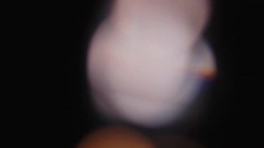 Çok renkli ışık siyah arkaplanda 4K görüntü sızdırıyor. Stüdyoda gaz sızıntısı var. Doğal aydınlatma ışınları bokeh etkisi. Çekimlerinizi birleştirmek, videoyu biçimlendirmek, geçişlerinizi
