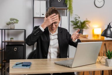 Genç, üzgün, stil sahibi bir iş adamı dizüstü bilgisayarda arama yapıyor, beklenmedik piyango sonuçlarını kaybediyor, servet kaybı, ofis masasında kötü haberler. Takım elbiseli, Kafkasyalı serbest çalışan.